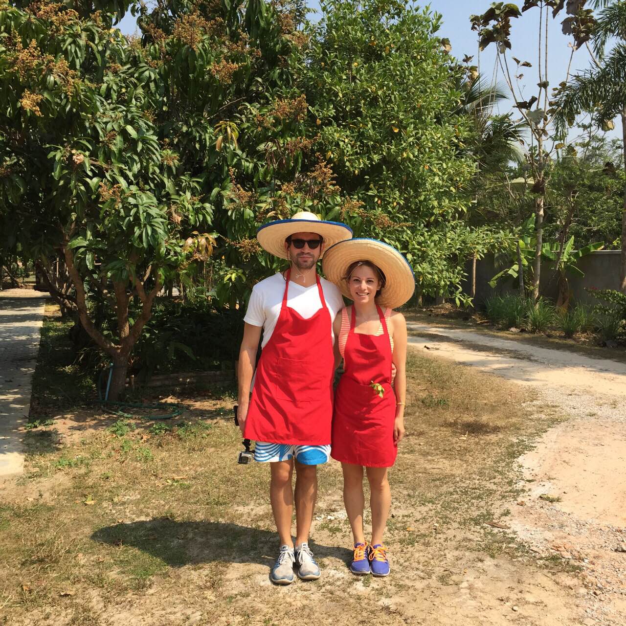 Thai cooking attire; red aprons and sombreros.